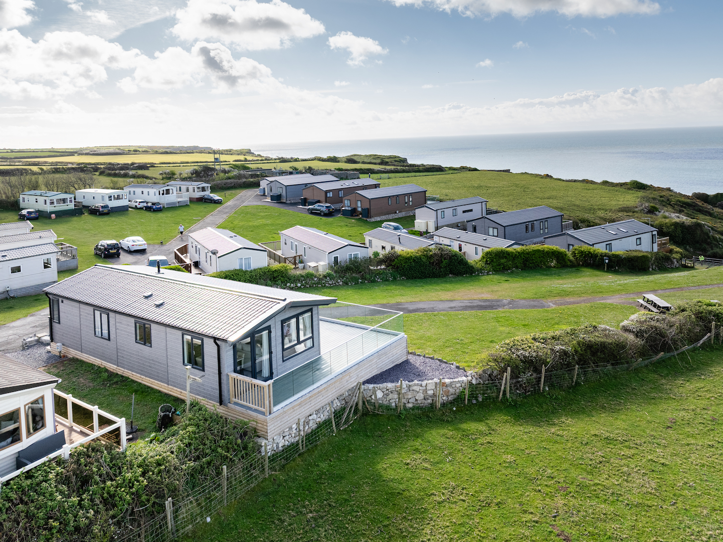 A modern static caravan holiday home situated on a scenic park with green surroundings
