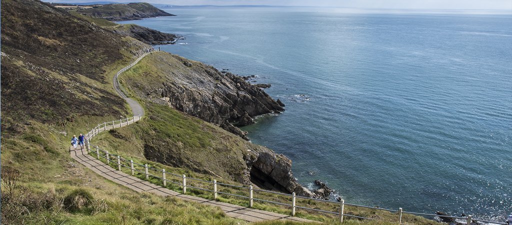 Hiking trail overlooking coastal cliffs and countryside in South Wales